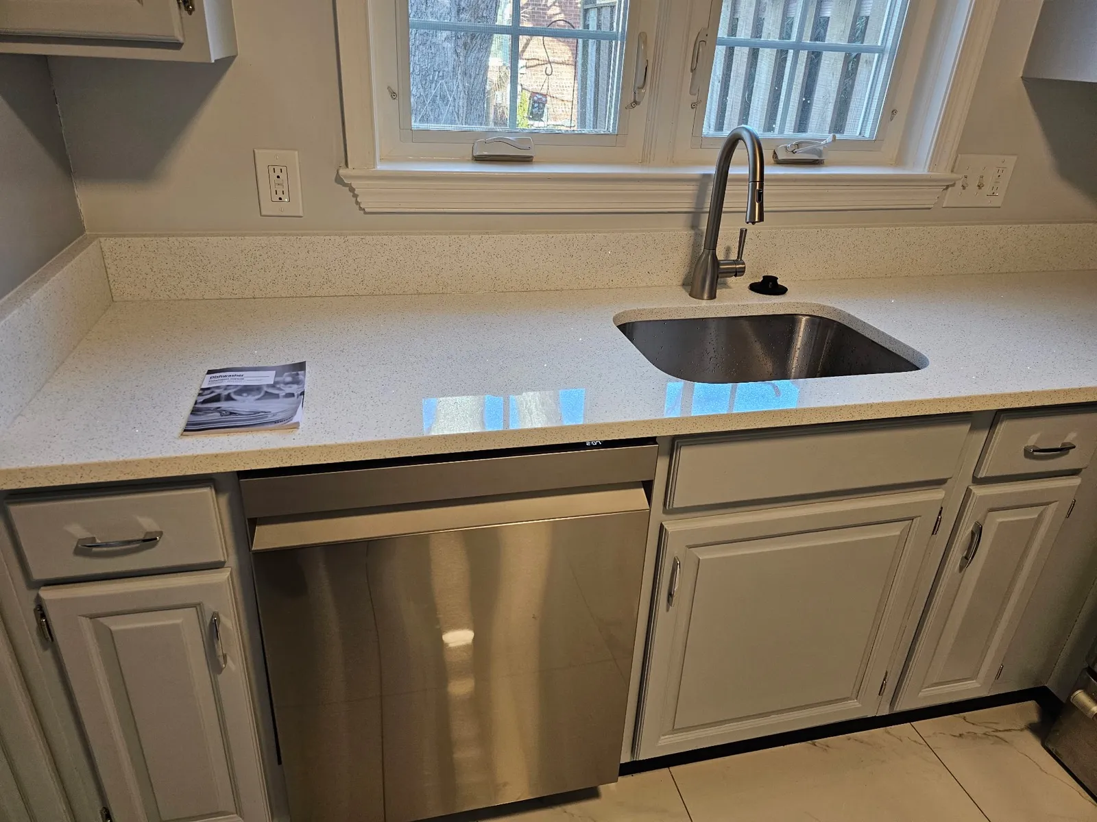 Kitchen sink, faucet and dishwasher installed in a remodeled kitchen