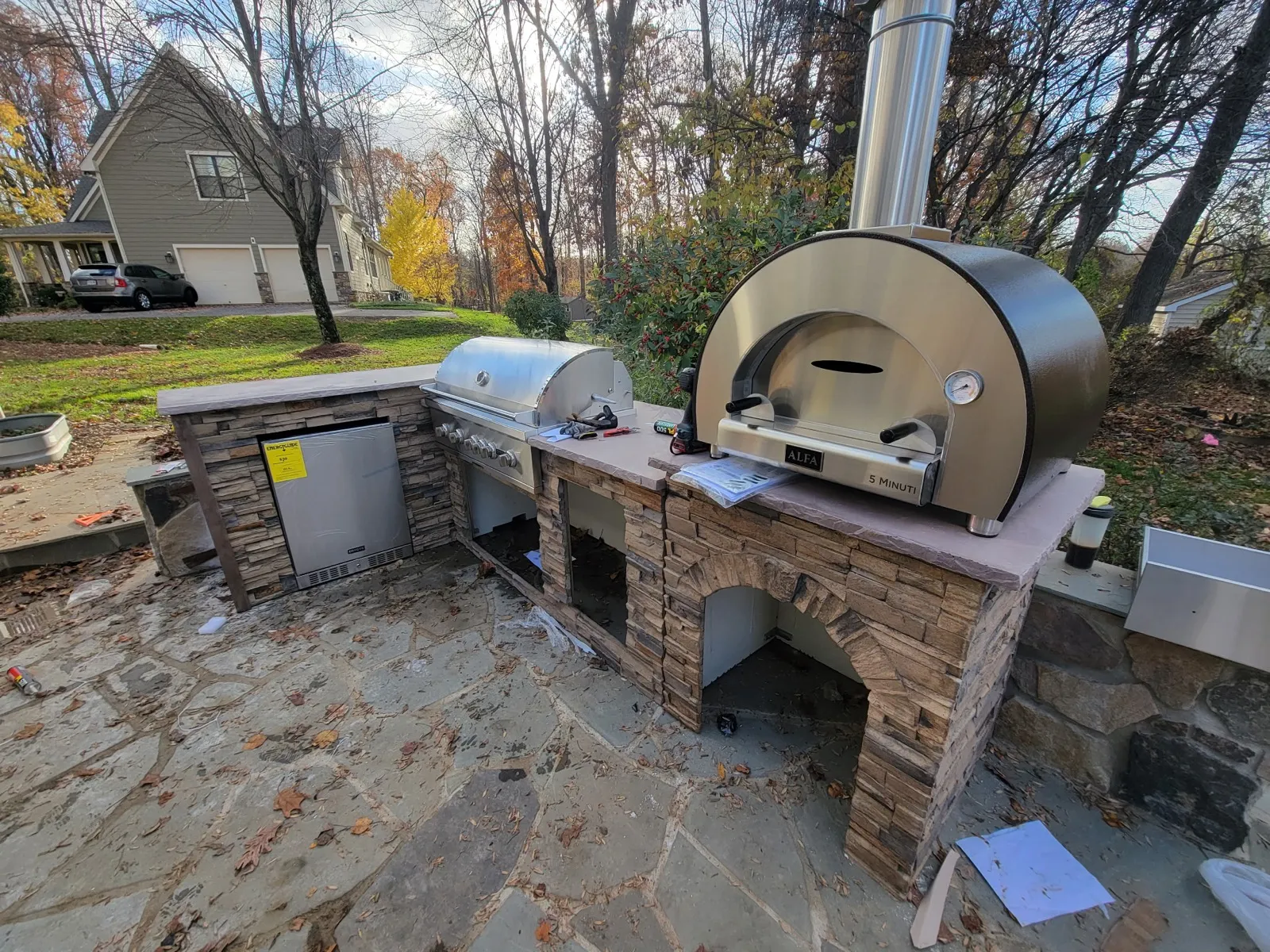 Outdoor kitchen build with pizza oven and stone base